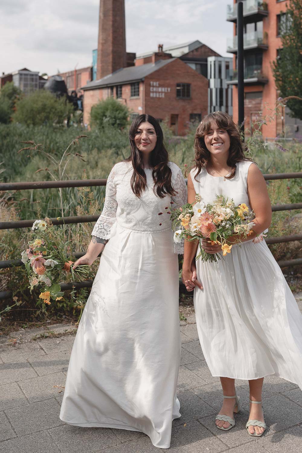 Two brides with bouquets outside in Sheffield. Photo ©Daisy Price Photography