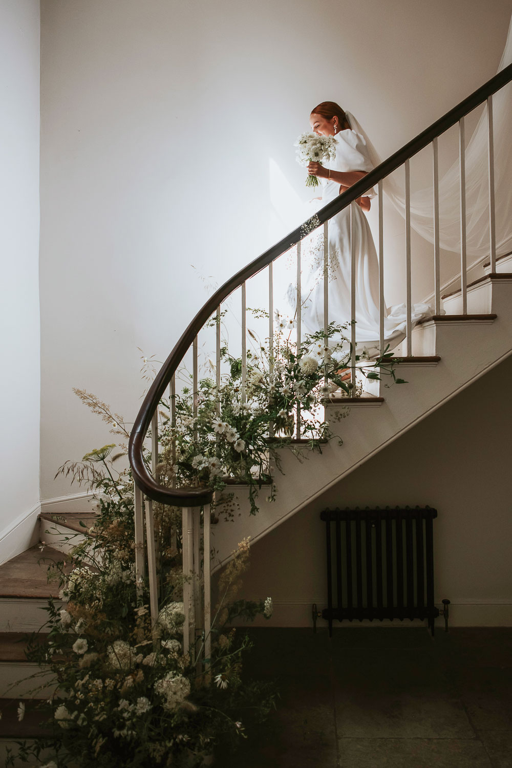 Bride walking down the stairs at Aswarby Rectory. Photo ©Rosie Kelly Photography
